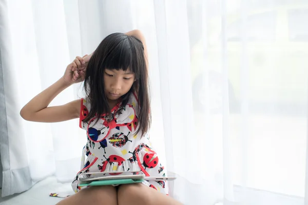Asijská dívka si hraje s počítačem tablet — Stock fotografie