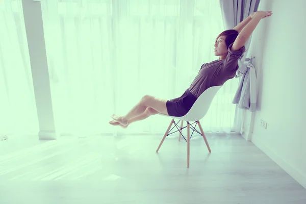 Frau sitzt zu Hause auf Stuhl — Stockfoto