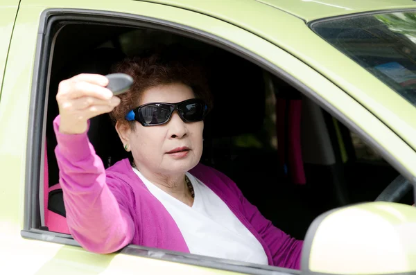 Senior vrouw in groene auto — Stockfoto