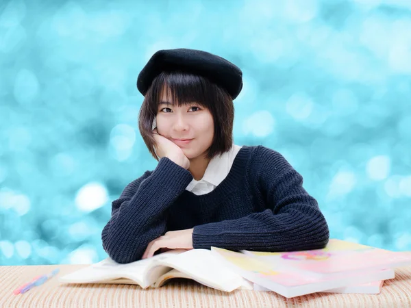 Asiatiska tonåring läsa böcker med blå suddig bakgrund — Stockfoto