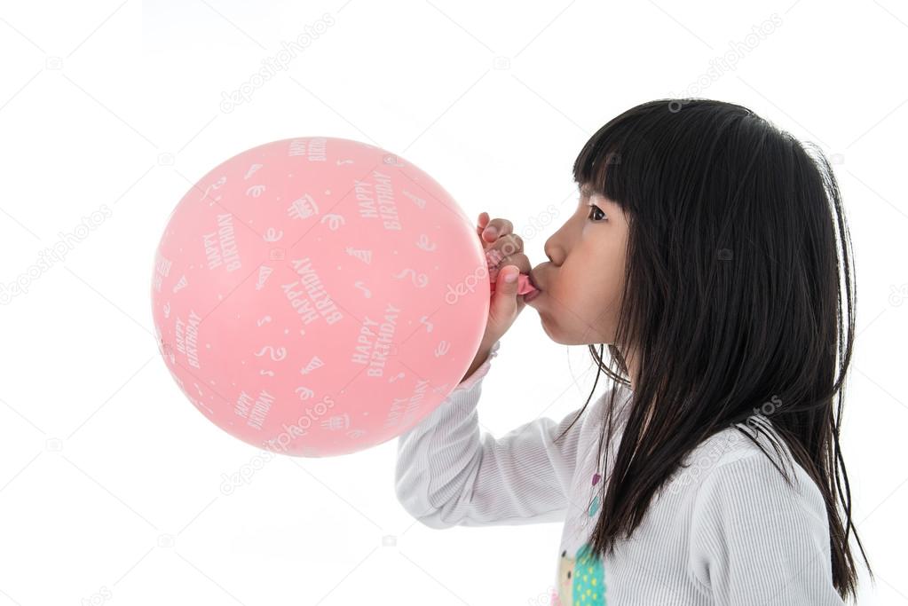 Girl inflate a pink balloon