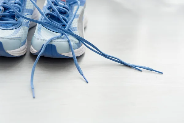 Вибірковий фокус крупним планом блакитне спортивне взуття на сірій підлозі . — стокове фото
