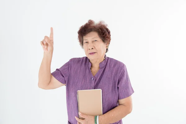 Portret van lachende senior vrouw lezen van een boek op wit. — Stockfoto