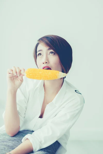 Asian girl eating yellow corn — Stock Photo, Image