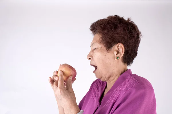 Asian senior woman eating an apple — Stock Photo, Image