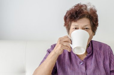 Yaşlı kadın evde bir fincan kahve ya da çay içme.