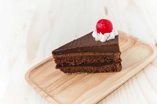 Fatia de bolo de chocolate na placa de madeira . — Fotografia de Stock