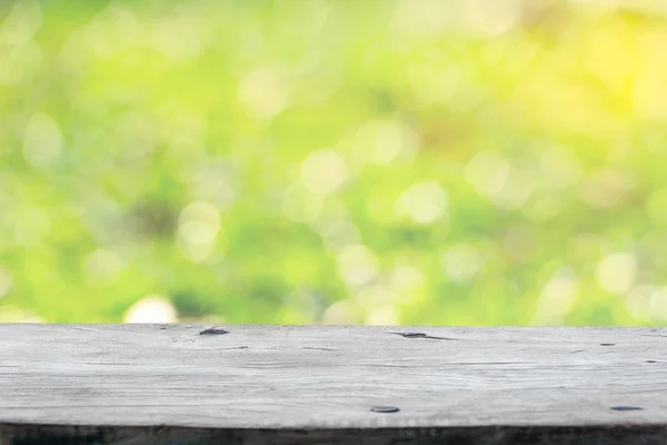 Lege houten dek tafel met groene achtergrond. Klaar voor product — Stockfoto