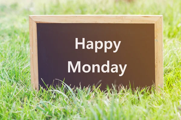 Happy Monday note on Blackboard on green grass . — Stok Foto