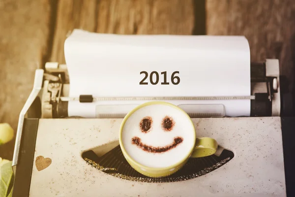 Máquina de escribir con taza de café cara feliz, tono sepia con 2016 . — Foto de Stock