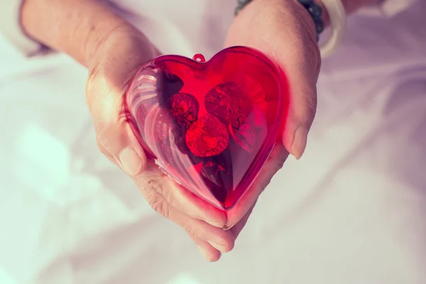 Heart in senior's hands — Stock Photo, Image