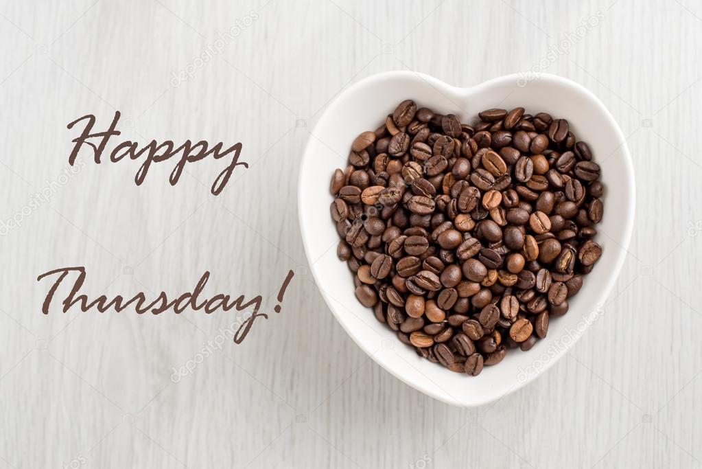 Happy Thursday note and coffee beans in a bowl in the form of hea