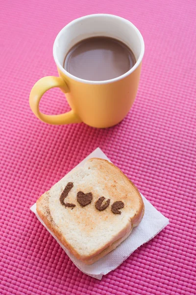 Liefde bericht op brood met gesneden en chocolade cup op roze yoga — Stockfoto