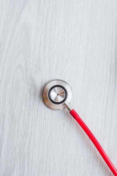 Czerwony medyczny stetoskop na szarym tle. — Zdjęcie stockowe