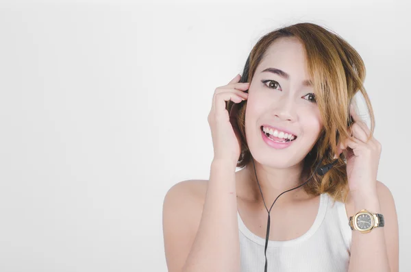 Kulaklık müzik dinleme üzerinde gri backgr kullanarak mutlu Asyalı kadın — Stok fotoğraf