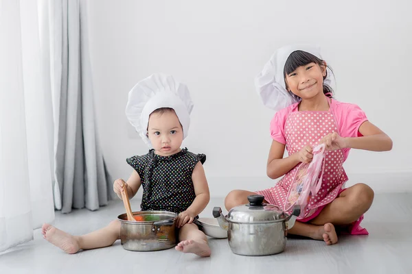 Азиатские дети играют в повара дома . — стоковое фото