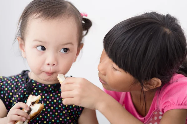 Asiatisk Tjej äter bröd hemma. — Stockfoto