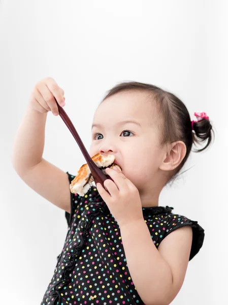 Asian girl eating bread at home. — Stock Photo, Image