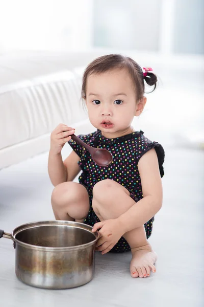 Aziatisch kind spelen een chef-kok thuis. — Stockfoto