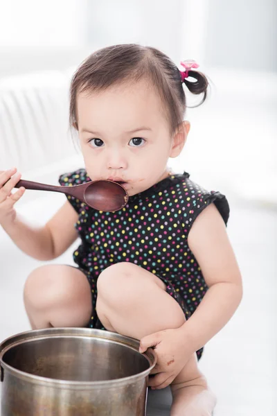 Aziatisch kind spelen een chef-kok thuis. — Stockfoto