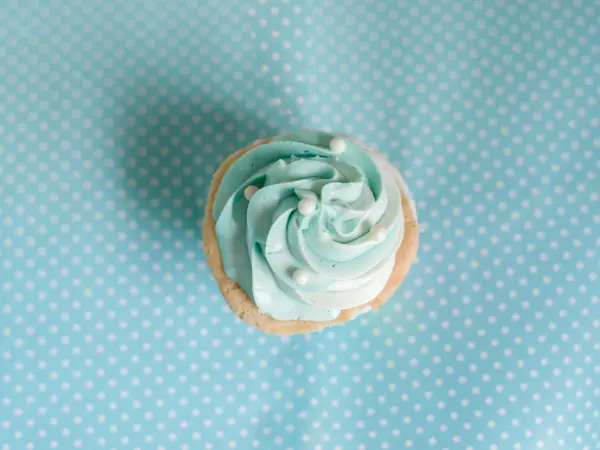Magdalena de cumpleaños de perla con crema de mantequilla glaseado en ba pastel azul — Foto de Stock