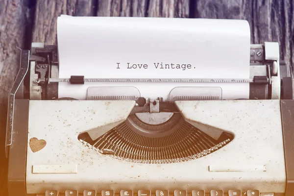 Vintage psací stroj na dřevěný stůl se zprávou, že miluji vinobraní — Stock fotografie