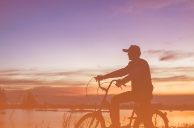 Cycler siluet Sunrise karşı güneş bulutlu gökyüzü ayarla