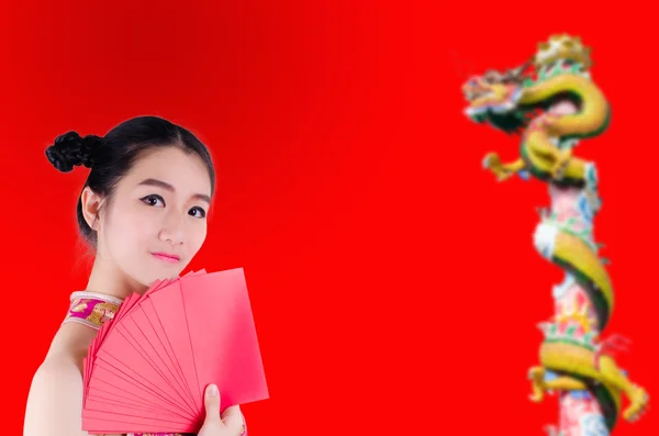 Asiatin verdeckt ihr halbes Gesicht mit roten Umschlägen. Chinesisch neu y — Stockfoto