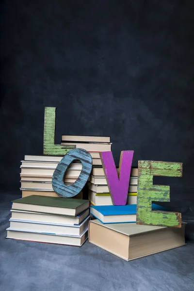 Pile of books and wooden letters — Stock Photo, Image