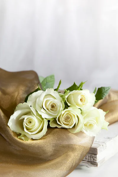 Parlak altın kumaş ile beş beyaz güller — Stok fotoğraf