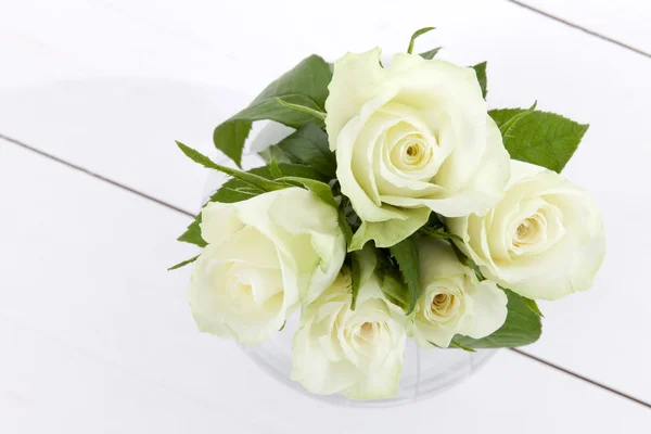 Five white roses and vase on white wooden floor — Stock Photo, Image