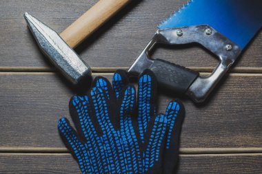 Tahta bir masada el aletleri ve koruyucu eldivenler..