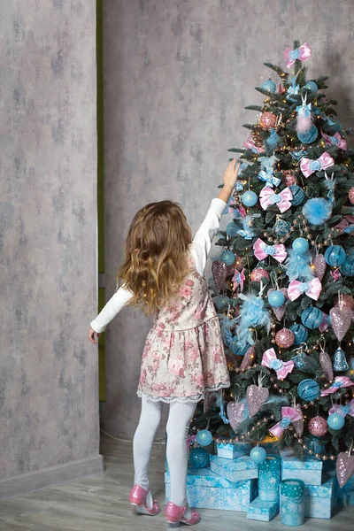 Een Klein Meisje Grijpt Naar Een Kerstboom Speelgoed Met Haar — Stockfoto