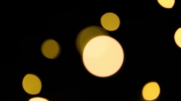 Жовті Золоті Вогні Гірлянди Розмиванні Чорному Тлі Боке Літаючих Кіл — стокове відео
