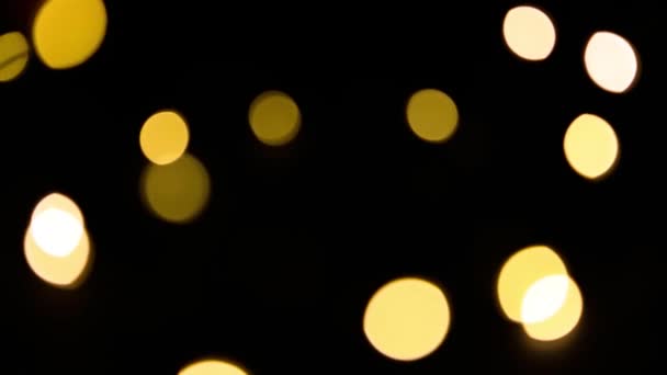 Жовті Золоті Вогні Гірлянди Розмиванні Чорному Тлі Боке Літаючих Кіл — стокове відео