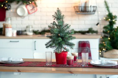 Mutfakta Noel dekoru, kutlamaya hazırlanıyor. Çatı katı şeklinde çelenk ışıkları, tabaklar, parlak lambalar. Noel ağacı, mutfak aletleri. Yeni yıl arifesi, Noel. Evin içi.
