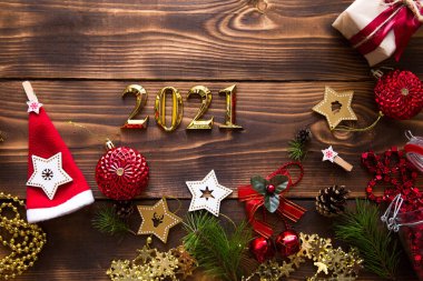 Noel dairesi 2021 yılının altın sayılar sembolüyle kurulmuştu. Tatil atmosferi, tahta yıldızlar, oyuncaklar, boncuklar, kırmızı toplar, arka planda ladin dalları. Metin için boşluk