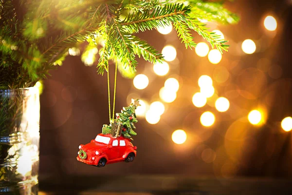 Noel dekoru - kırmızı retro araba çatıda hediye kutularıyla Noel ağacı taşıyor. Metin için boşluk. Yeni yıl. Çam ağacının dalında çelenk, çelenk, bokeh, tatil arka planı.