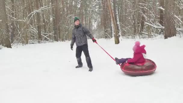 Dad Rolls His Daughter Tube Circle Snow Winter Timelapse Tubing — Stock Video