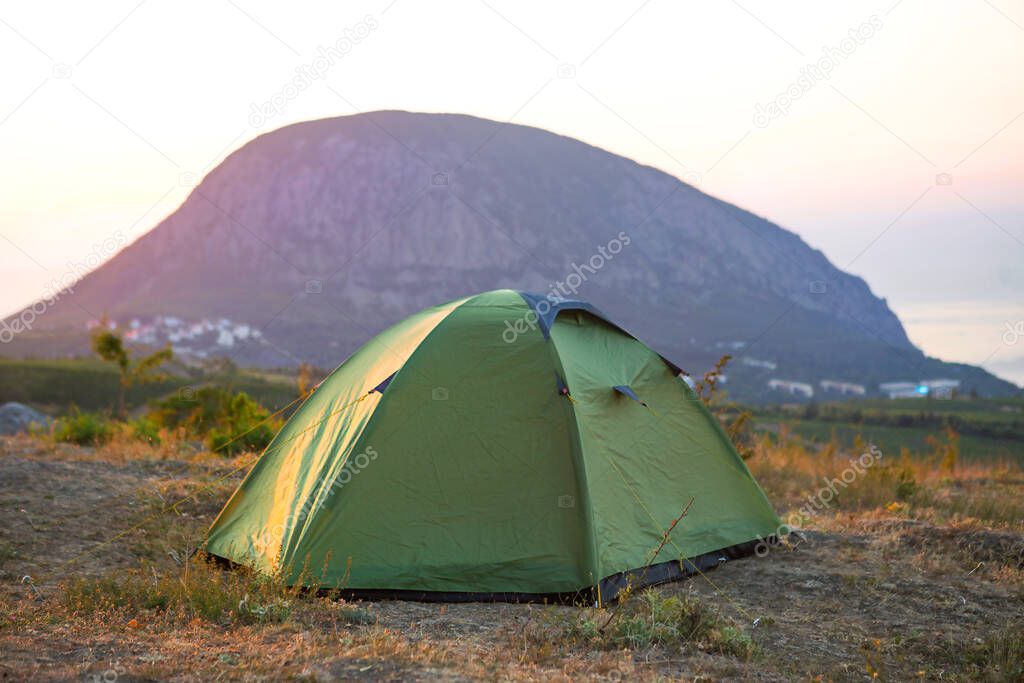 Installed tourist tent in the mountains with a view of the sea and sunrise. Domestic tourism, active summer trip, family adventures. Ecotourism, camping, sports mountain hiking. Ayu-Dag, Crimea.