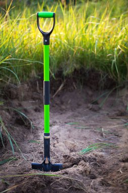 Kürek, baharda ekmek için toprağa yerleştirilir. İlkbahar, bahçe bitkileri, bir arsa üzerinde çalışmak, peyzaj, bahçıvanlık, büyüyen çiçekler, bahçede meyve ekinleri. Boşluğu kopyala