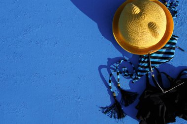 Mavi arka planda bir plaj tatili için kadın aksesuarları. Denize yolculuk konsepti, rahatlama, yüzme, ultraviyole koruma, bronzlaşma. Turizm ve seyahat acentesi. Mesaj için yer. Çerçeve. Düz Yatay