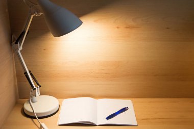 Table lamp in the loft style at the workplace at home. A place for a student to study, to work remotely. Background, copyspace.