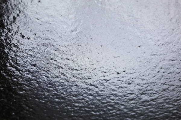 Penceredeki donmuş su. Buzlu şeffaf cam şeffaftır, dondurucu yağmurdur. Yağmurdan sonra araba ön camı - kışın yol güvenliği, görüş mesafesi yok. Arkaplan