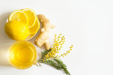 Bir fincanda bitki çayı, zencefil, limon ve akasya - soğuk mevsimde bağışıklık sistemini güçlendirir. Alerji, ateş, grip. Beyaz arka planda sağlık ve malzemeler için vitamin içeceği. Uzayı kopyala, düz olarak