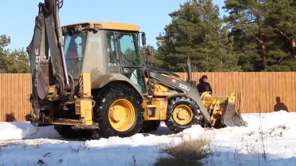 Gul Traktor Rensar Snö Med Hink Längs Staketet Förberedelser För — Stockvideo