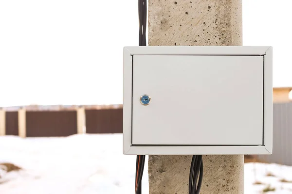Elektrik direğinin üzerindeki elektrik kutusuna hava yoluyla elektrik bağlanıyor. İnşaat için bir arsa elektrik desteğine bağlanıyor