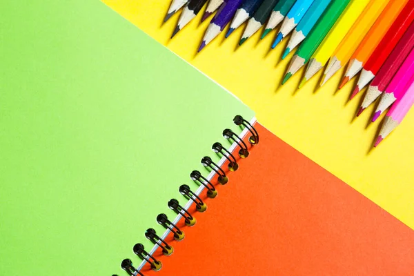 彩虹调色板彩色铅笔与螺旋笔记本电脑黄色背景 平面躺下 回到学校 学生招募 艺术家 绘画课 复制空间 促进创造力的文体 — 图库照片