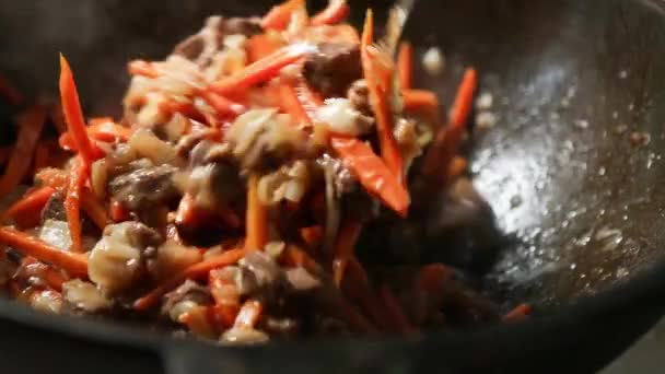 숟가락으로 요리하여 양파와 당근을 냄비에 뜨거운 증기와 넣는다 철기로 드리온 — 비디오