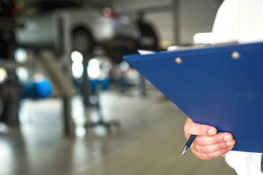 Tamirat ve bakım için tableti olan bir araba servis istasyonunda resepsiyonist. Tamir alanı, telefon konsültasyonu, teşhis, araba bakımı. Boşluğu kopyala
